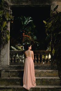 Rear view of woman standing against trees