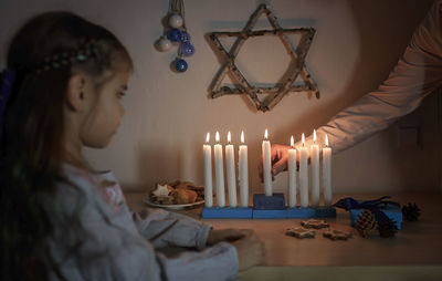 Midsection of woman looking at illuminated lamp