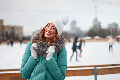 Portrait of smiling woman winking while standing outdoors during winter