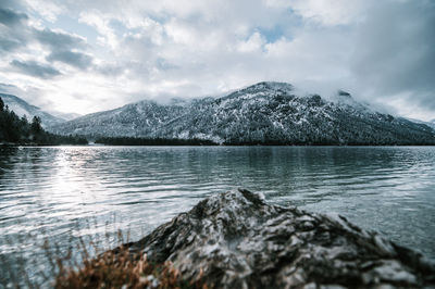 Scenic view of lake by mountains against sky