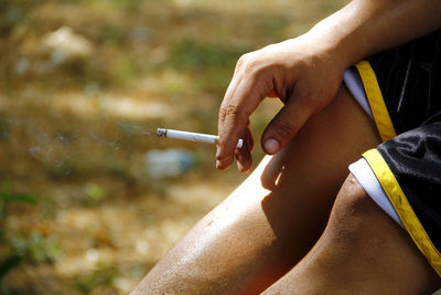 Midsection of man smoking cigarette