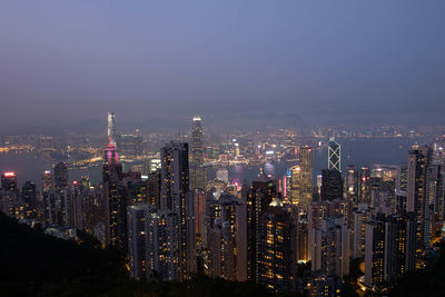 Illuminated buildings in city against sky