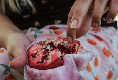 Midsection of person holding pomegranate 