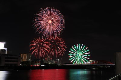Firework display over river at night