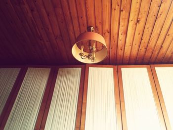 Low angle view of illuminated lighting equipment hanging on ceiling