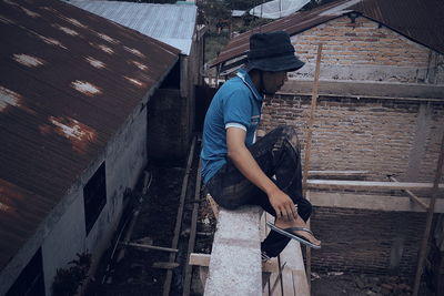 Worker sitting on wall at construction site