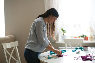 Craftswoman makes brushes from threads. concept creativity and handmade, toning in the real interior
