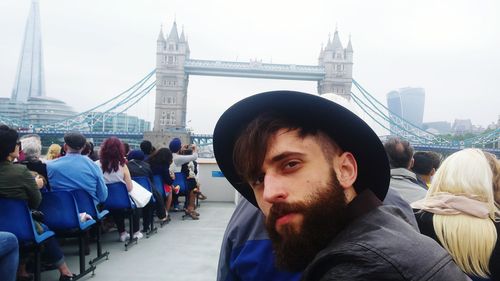 Portrait of bearded man on boat against tower bridge in city