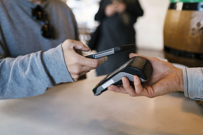 Customer paying through contactless payment by using smart phone at a bar