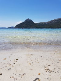 Scenic view of beach against clear blue sky