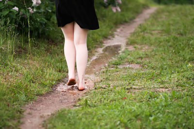 Low section of woman walking on footpath