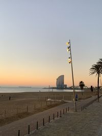 Scenic view of beach against clear sky during sunset