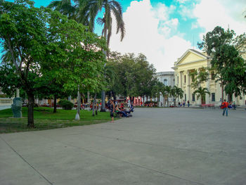 People on footpath by buildings in city