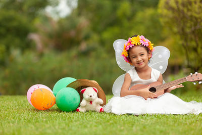 Cute girl playing with ball on field