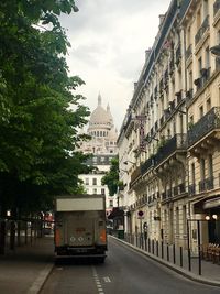 Cars on road in city against sky