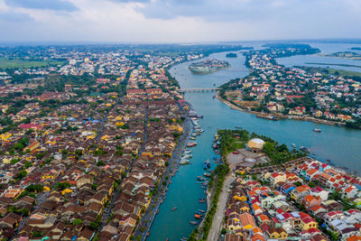 High angle view of city by sea against sky