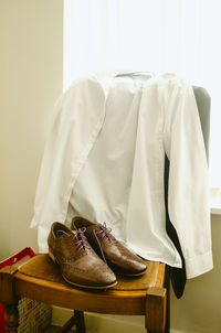 Close-up of shoes and shirt on chair at home