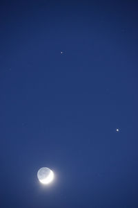 Low angle view of moon against blue sky