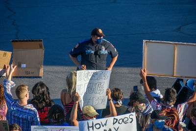 Rear view of people standing against buildings