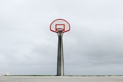 Low angle view of basketball hoop on road against sky