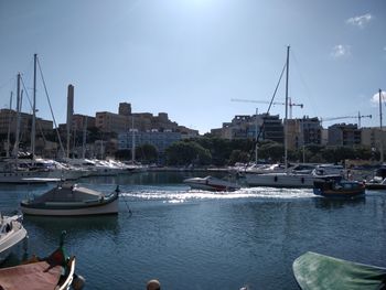 Sailboats moored in harbor