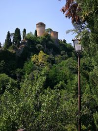 Low angle view of water tower and trees against sky