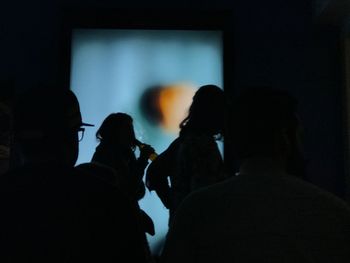 Silhouette people standing in darkroom