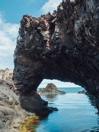 Rock formation in sea against sky