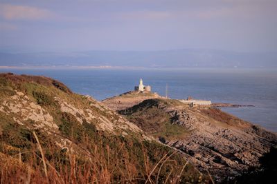 Scenic view of sea and mountains against sky