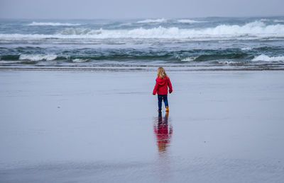 Rear view of girl standing on beach