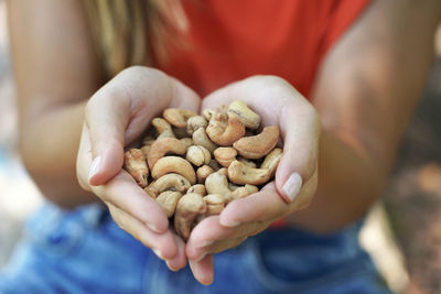 Cashew nuts. close-up of female hands holding cashew nuts.