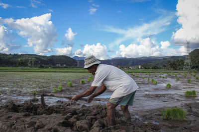 Man working on field against sky