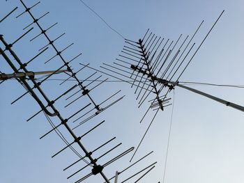 Low angle view of electricity pylon against clear sky