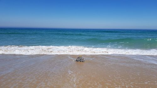 Scenic view of sea against clear blue sky