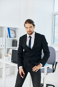 Portrait of young man standing in office