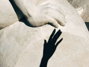 Shadow of hand on sculpture