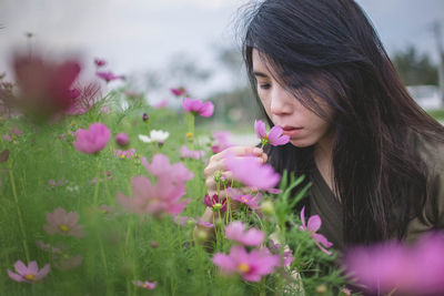 Woman smelling flower on plant