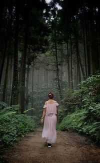 Rear view of woman walking in forest