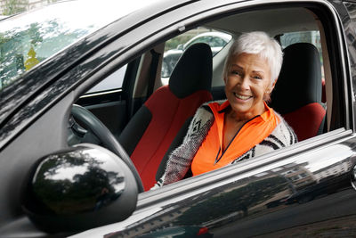 Portrait of smiling woman sitting in car