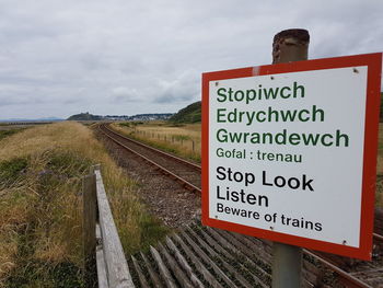 Close-up of road sign against sky