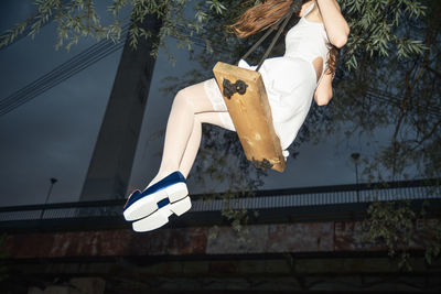 Low angle view of man hanging from tree