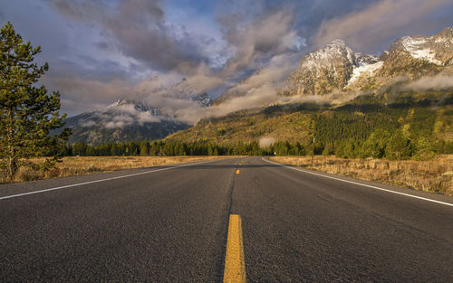 Road by mountains against sky