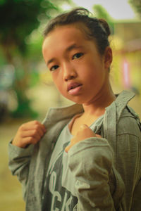 Portrait of cute girl wearing jacket while standing outdoors