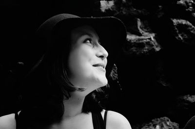 Close-up of smiling young woman wearing hat looking away outdoors