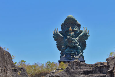 Low angle view of statue against clear blue sky