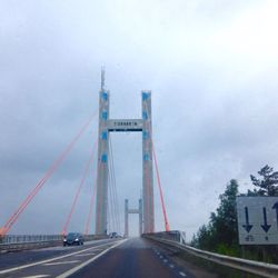 Bridge over river against cloudy sky