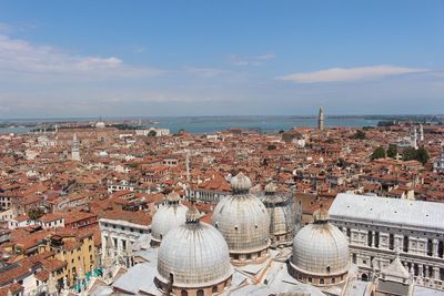 High angle view of city by sea against sky