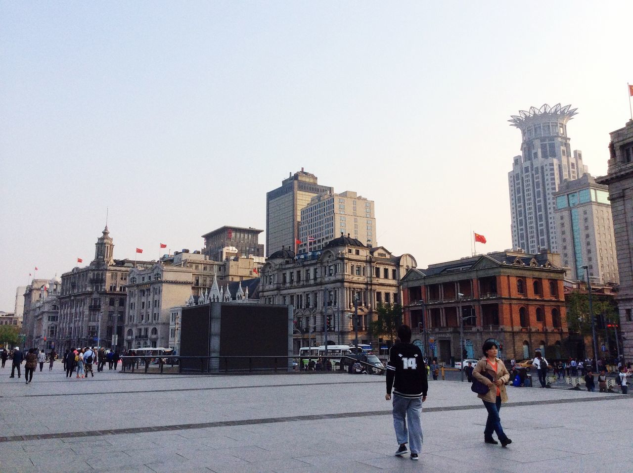 building exterior, architecture, built structure, city, large group of people, men, city life, walking, person, lifestyles, street, clear sky, leisure activity, city street, building, mixed age range, copy space, road, full length