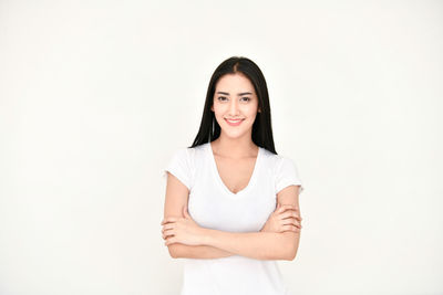Portrait of smiling young woman against white background