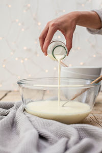 Close-up of hand pouring drink in bowl